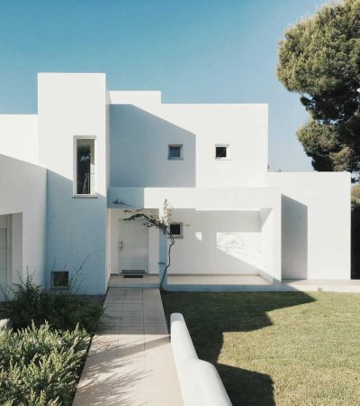 white concrete house near green tree during daytime