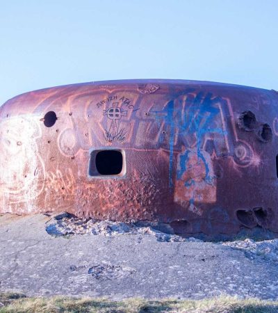 a rusted out round building with graffiti on it