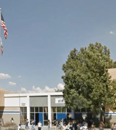 beige brick school building with trees