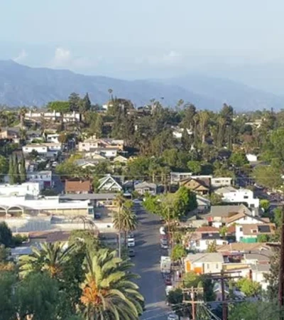 a city with trees and mountains in the background