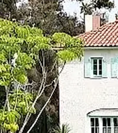 a white building with a red roof and a green roof