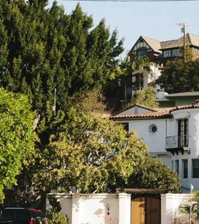 a white building with a large tree in the background