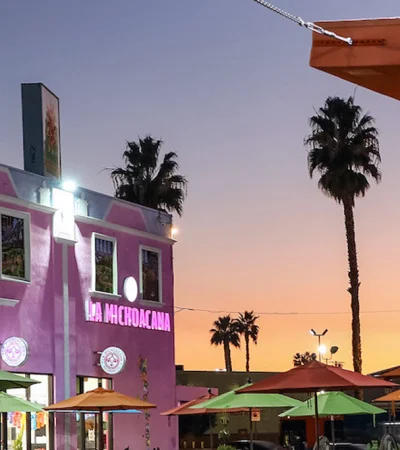 a building with umbrellas and palm trees