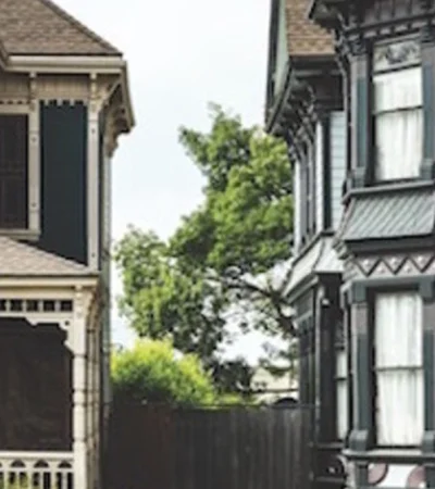a row of houses with a fence and trees