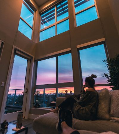 a person sitting on a couch looking out a window
