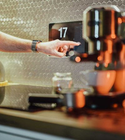 a person pressing a button on a coffee machine
