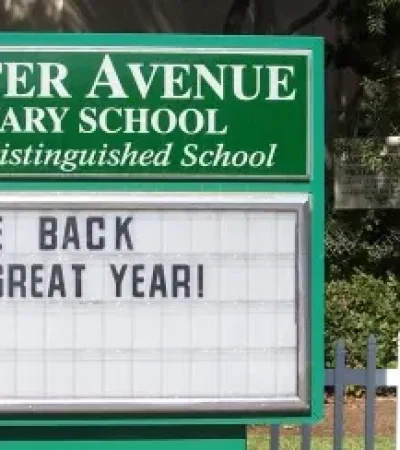 green and white sign in front of school