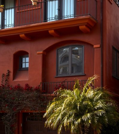 a red building with a palm tree in front of it