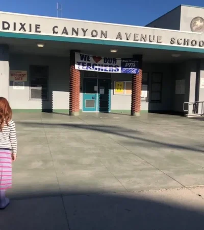 little redhead girl in front of school