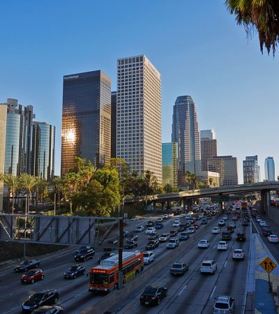 a traffic on a freeway with a city skyline in the background