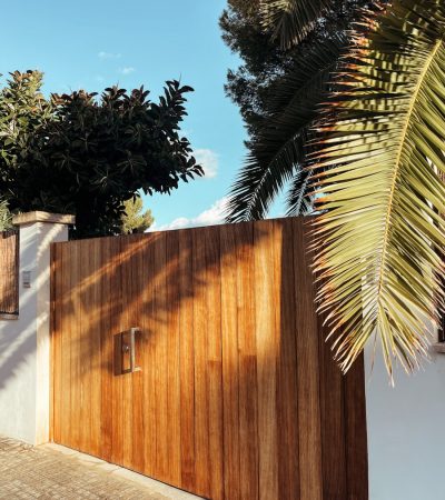 a wooden gate with a palm tree in the background