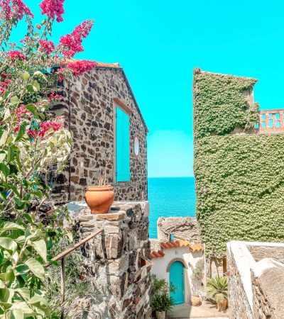 green and brown concrete house near body of water during daytime