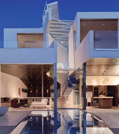 white and brown paneled modern luxury home at twlight