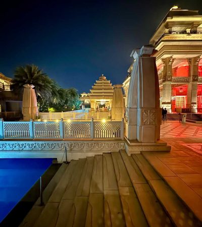 a night view of a building with a pool in front of it