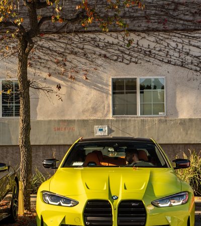 a yellow sports car parked next to a tree