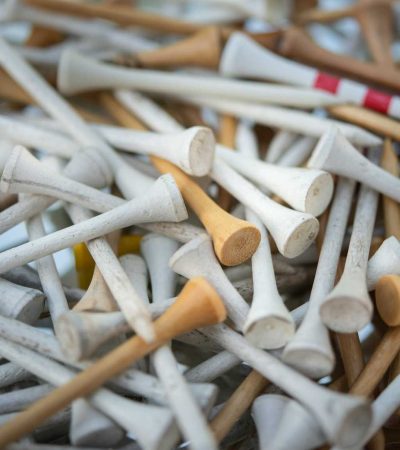 white and brown wooden golf tees in a pile