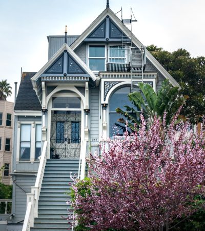 white and gray wooden house near pink flowers