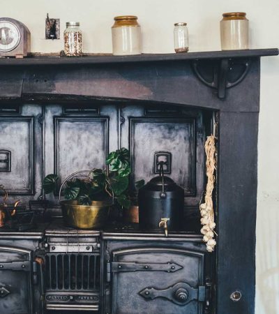 brown wooden kitchen shelf with ceramic jars on top