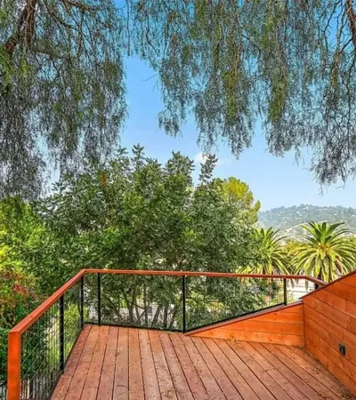 a deck with a railing and trees