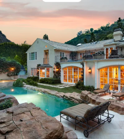 a house with a pool and a large stone patio