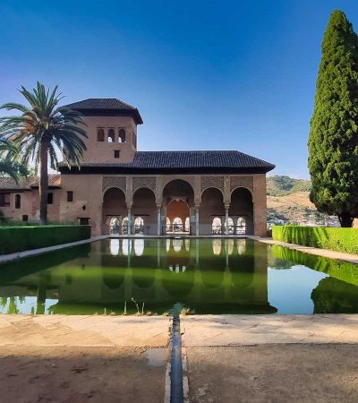 historic home for sale with green trees beside body of water during daytime