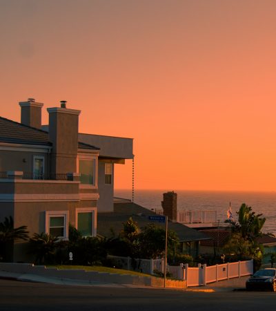 white and brown concrete building near green trees during sunset