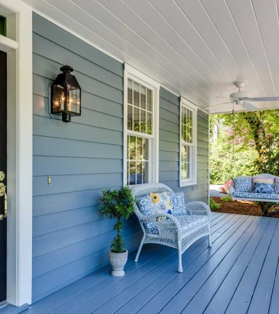 a porch with two chairs and a table on it