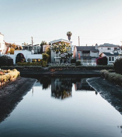 a river running through a small town next to tall buildings